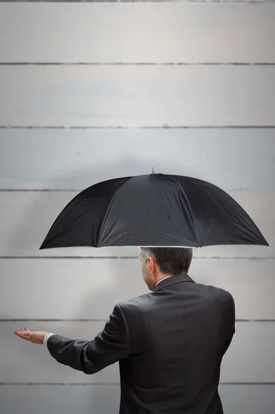 Mature businessman holding an umbrella — Stock Photo, Image