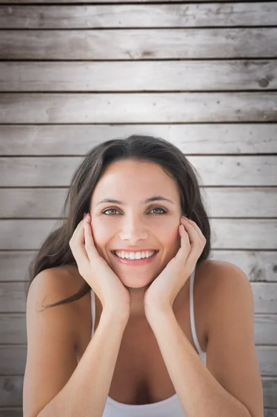 Smiling brunette against wooden planks — Stock Photo, Image