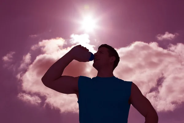 Homme buvant de l'eau contre le ciel bleu — Photo