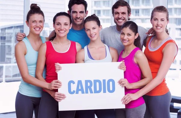 Cardio against fit smiling people holding blank board — Stock Photo, Image