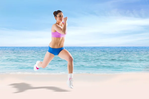 Fit brunette running and jumping — Stock Photo, Image