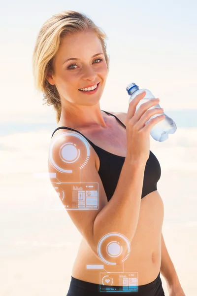 Fit blonde drinking water on the beach — Stock Photo, Image