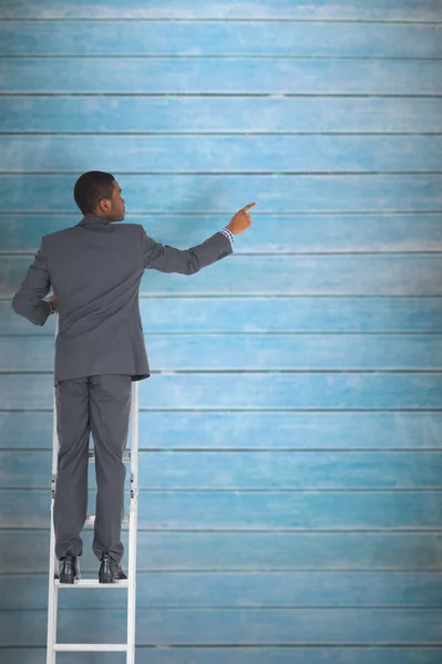 Empresario de pie en la escalera señalando — Foto de Stock