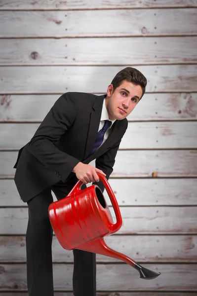 Empresário molhando com lata vermelha — Fotografia de Stock