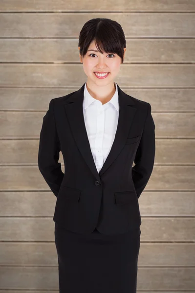 Mujer de negocios sonriente contra tablones de madera —  Fotos de Stock