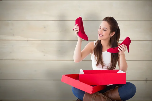 Brunette holding red shoes — Stock Photo, Image