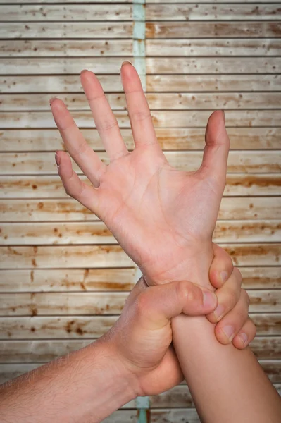 Male hand grabbing female wrist — Stock Photo, Image