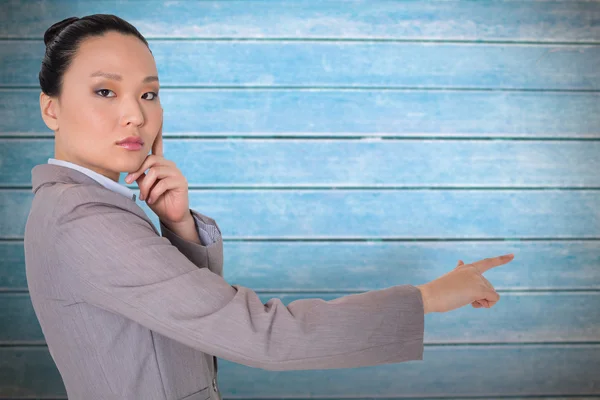 Pensativo asiático mujer de negocios señalando — Foto de Stock