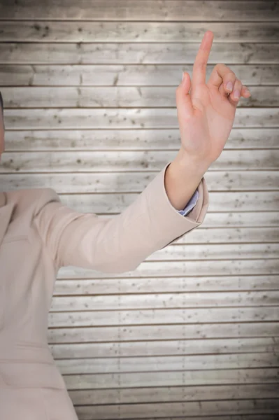 Businesswoman pointing against wooden planks — Stock Photo, Image