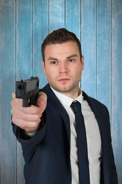 Serious businessman pointing gun — Stock Photo, Image