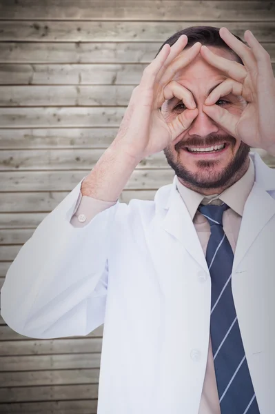 Smiling doctor forming eyeglasses with hands — Stock Photo, Image