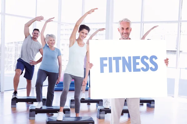 Man showing large poster against fitness — Stock Photo, Image
