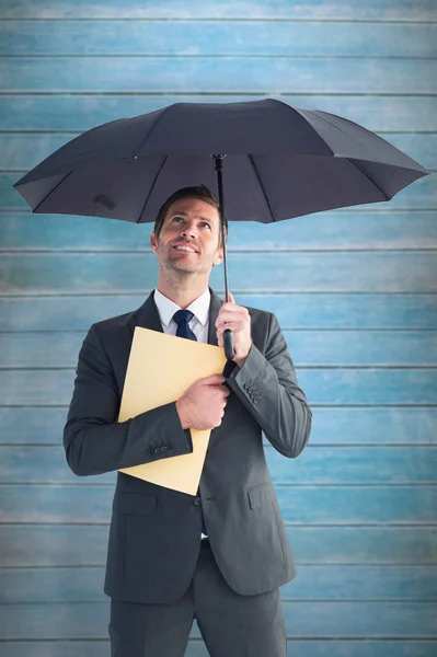 Biznesmen schronienie pod parasolem — Zdjęcie stockowe
