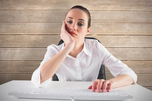 Bored businesswoman typing on keyboard — Stock Photo, Image
