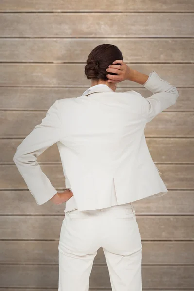 Thinking businesswoman against wooden planks — Stock Photo, Image