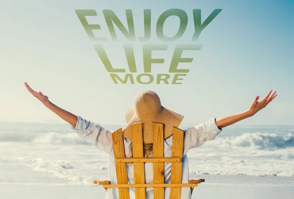 Woman relaxing in deck chair by sea — Stock Photo, Image