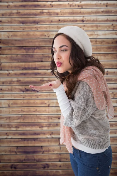 Pretty brunette in white hat blowing — Stock Photo, Image