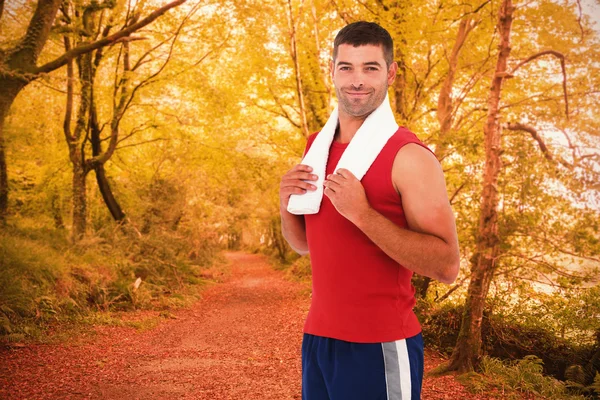 Fit man against autumn scene in forest — Stock Photo, Image