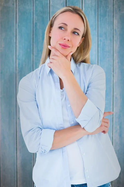 Blonde denken met hand op kin — Stockfoto