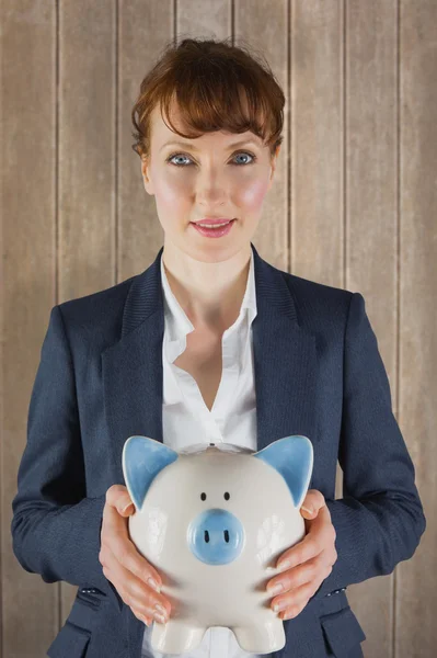 Businesswoman showing piggy bank — Stock Photo, Image