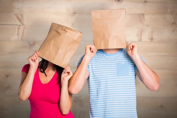 Jovem casal com sacos sobre cabeças — Fotografia de Stock