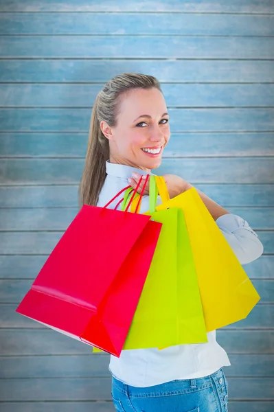 Leende blondin håller påsar — Stockfoto