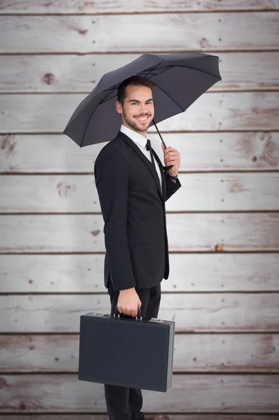 Zakenman onder paraplu met werkmap — Stockfoto