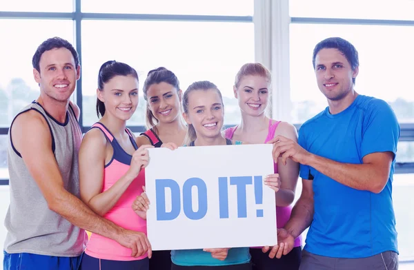 Doe het! tegen portret van een groep van fitness klasse houden blan — Stockfoto