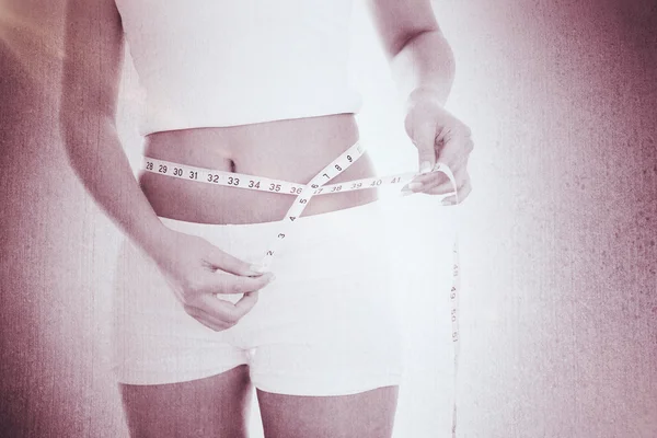 Midsection of woman measuring waist — Stock Photo, Image