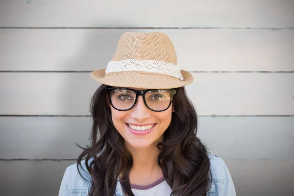 Brunette glimlachend tegen houten planken — Stockfoto