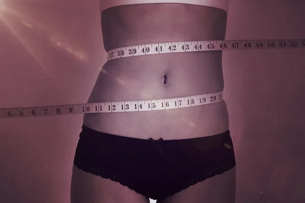 Slim mage omgitt av målebånd – stockfoto