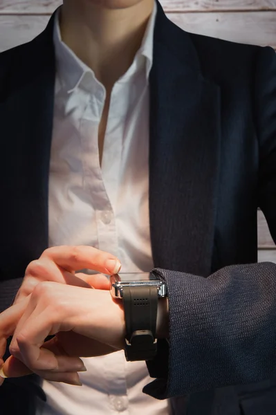 Businesswoman with watch against wooden planks — Stock Photo, Image