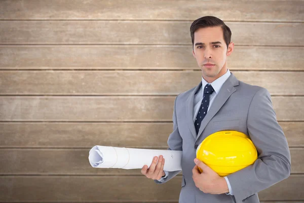 Arquitecto serio sosteniendo planes y sombrero duro —  Fotos de Stock