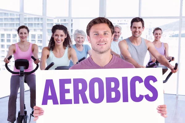 Man holding up a sign against aerobics — Stock Photo, Image