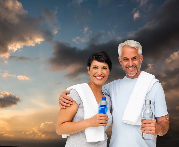 Pareja feliz ajuste contra el cielo azul y naranja —  Fotos de Stock