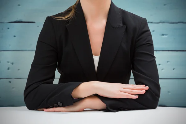 Mujer de negocios sentada en el escritorio con los brazos cruzados —  Fotos de Stock