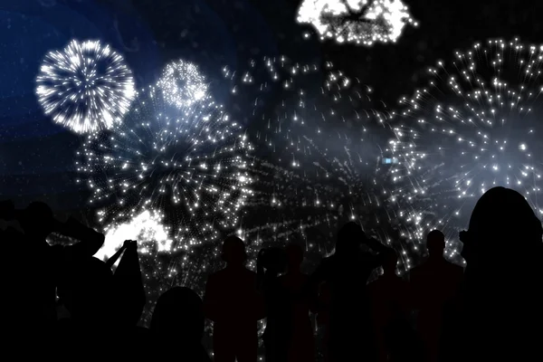 Silhouettes of cheering people against fireworks — Stock Photo, Image
