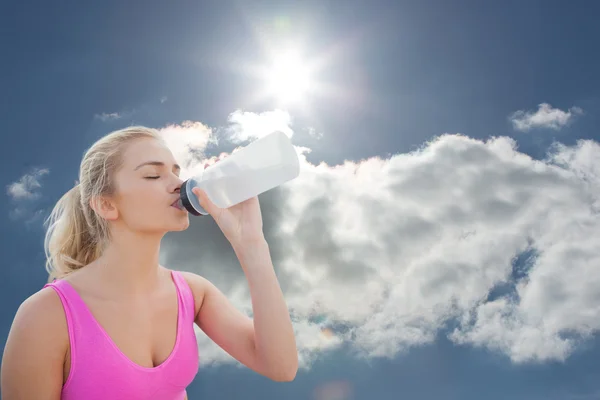 Žena pitné vody proti modré obloze — Stock fotografie