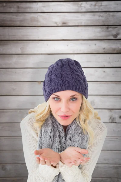 Blondin i vinter mode blåser över händerna — Stockfoto