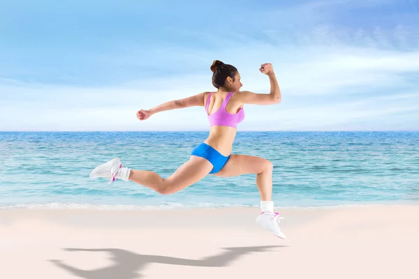 Fit brunette running and jumping — Stock Photo, Image