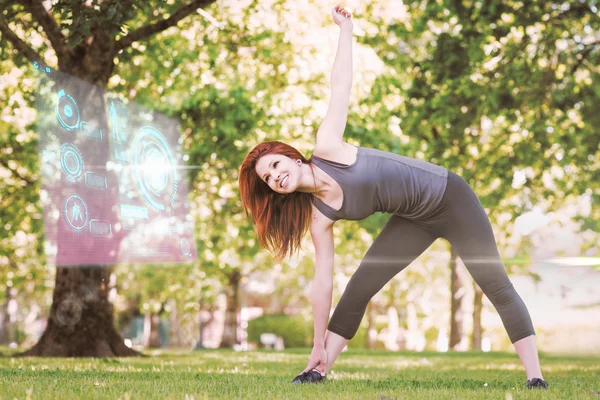 Athletic rödhårig stretching i park — Stockfoto