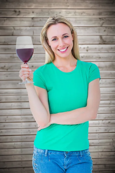 Leende blondin anläggning glas rött vin — Stockfoto