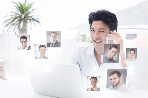 Sonriente hombre usando su portátil y hablando — Foto de Stock