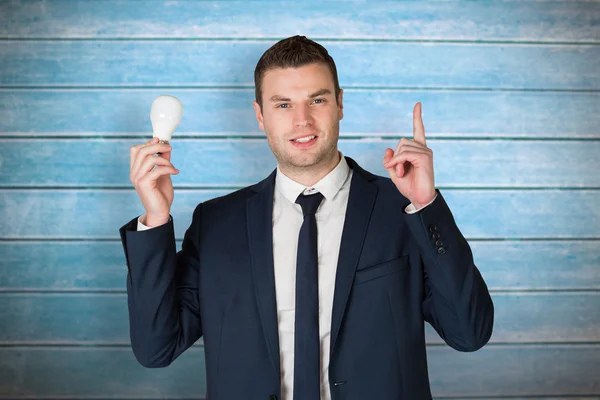 Zakenman lamp te houden en wijzen — Stockfoto