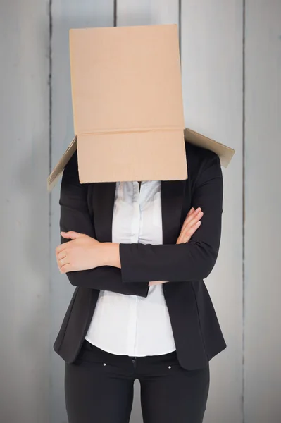 Businesswoman lifting box off head — Stock Photo, Image