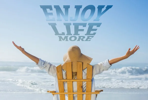 Woman relaxing in deck chair by sea — Stock Photo, Image