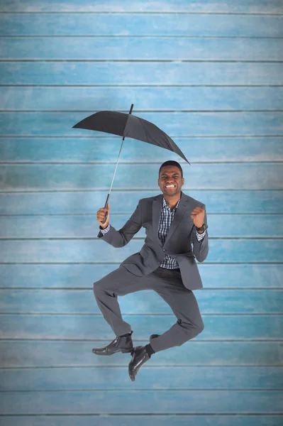 Geschäftsmann jubelt und hält Regenschirm — Stockfoto