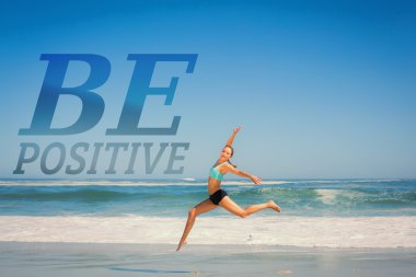 Fit woman jumping gracefully on the beach clipart
