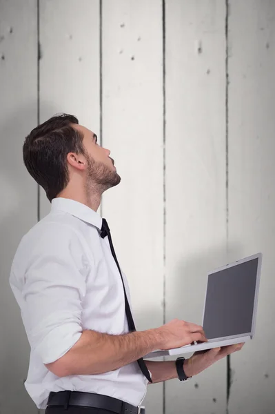 Sofistike iş adamı ayakta kullanarak dizüstü bilgisayar — Stok fotoğraf