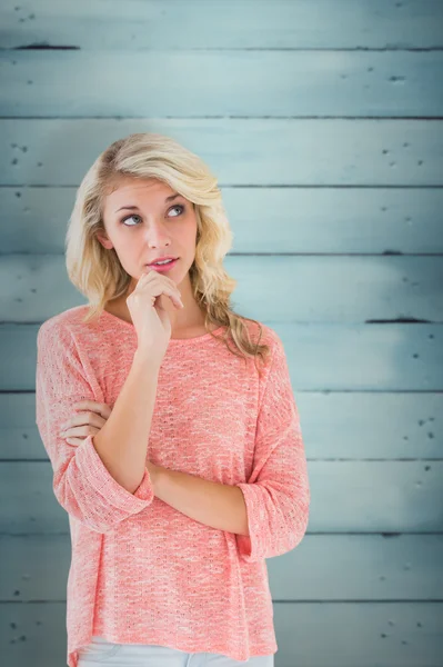 Blonde denken met hand op kin — Stockfoto